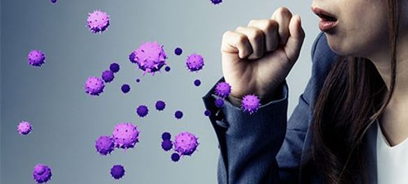 Person coughing, with hand over their mouth and large virus graphics being expelled from their cough. 