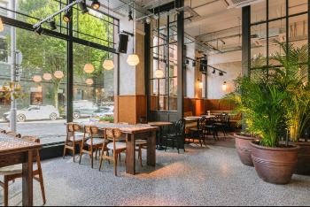 The inside of the Amelia Hall venue, showing tables, chairs and some plants.