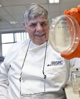 George Lomonossofft in a lab holding a petri dish.