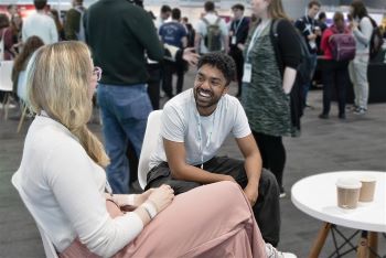 Photo of two young adults in seats conversing